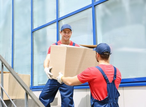 Moving team navigating stairs in a Finsbury Park flat conversion